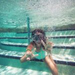 person swimming under water during daytime